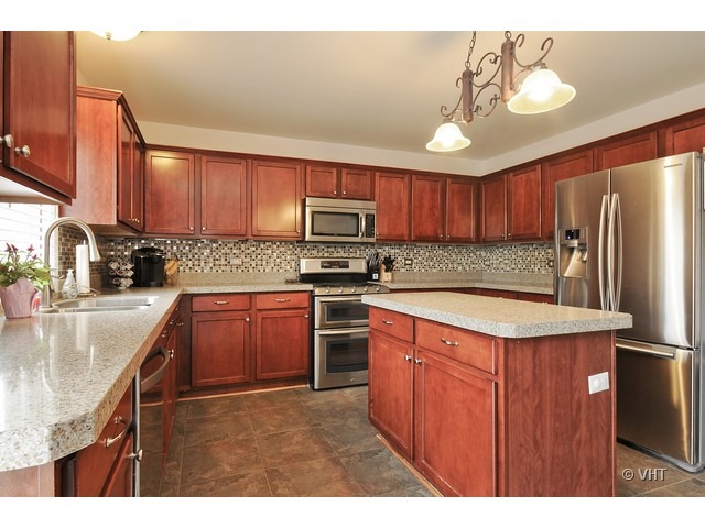 609 Homeland Road Matteson, IL 60443 - Photo 5 of 18 a kitchen with stainless steel appliances granite countertop a sink stove microwave and refrigerator