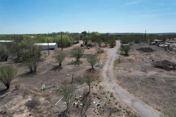 a view of a dry yard with trees