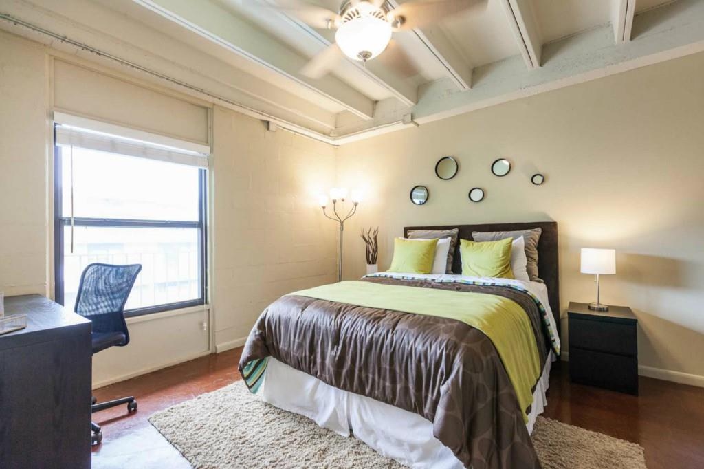 2408 Leon Street, Unit 104 Austin, TX 78705 - Photo 3 of 5 a bedroom with a bed and wooden floor