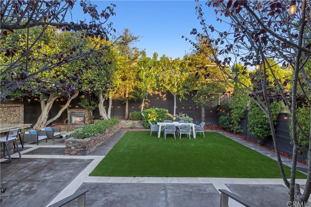 970 Baja Street Laguna Beach, CA 92651 - Photo 22 of 27 a view of a backyard with table and chairs and potted plants and large trees