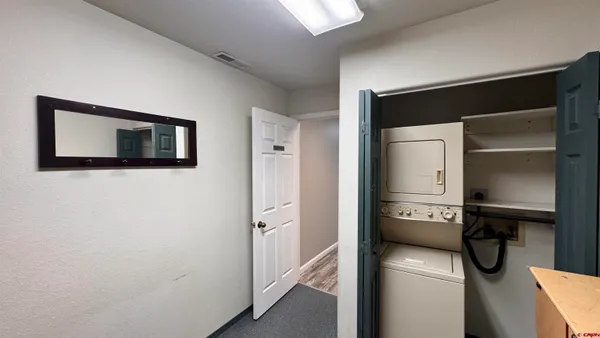 a view of a hallway with wooden floor and closet area