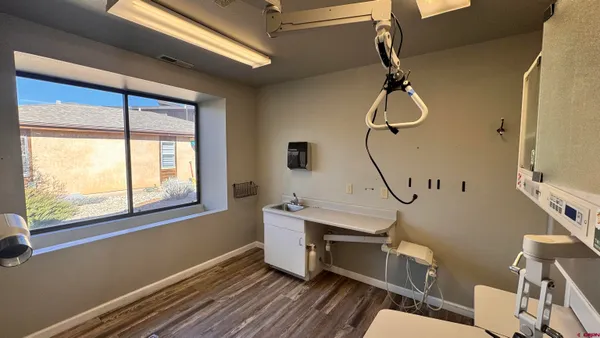 a hallway with wooden floor cabinets and a kitchen space