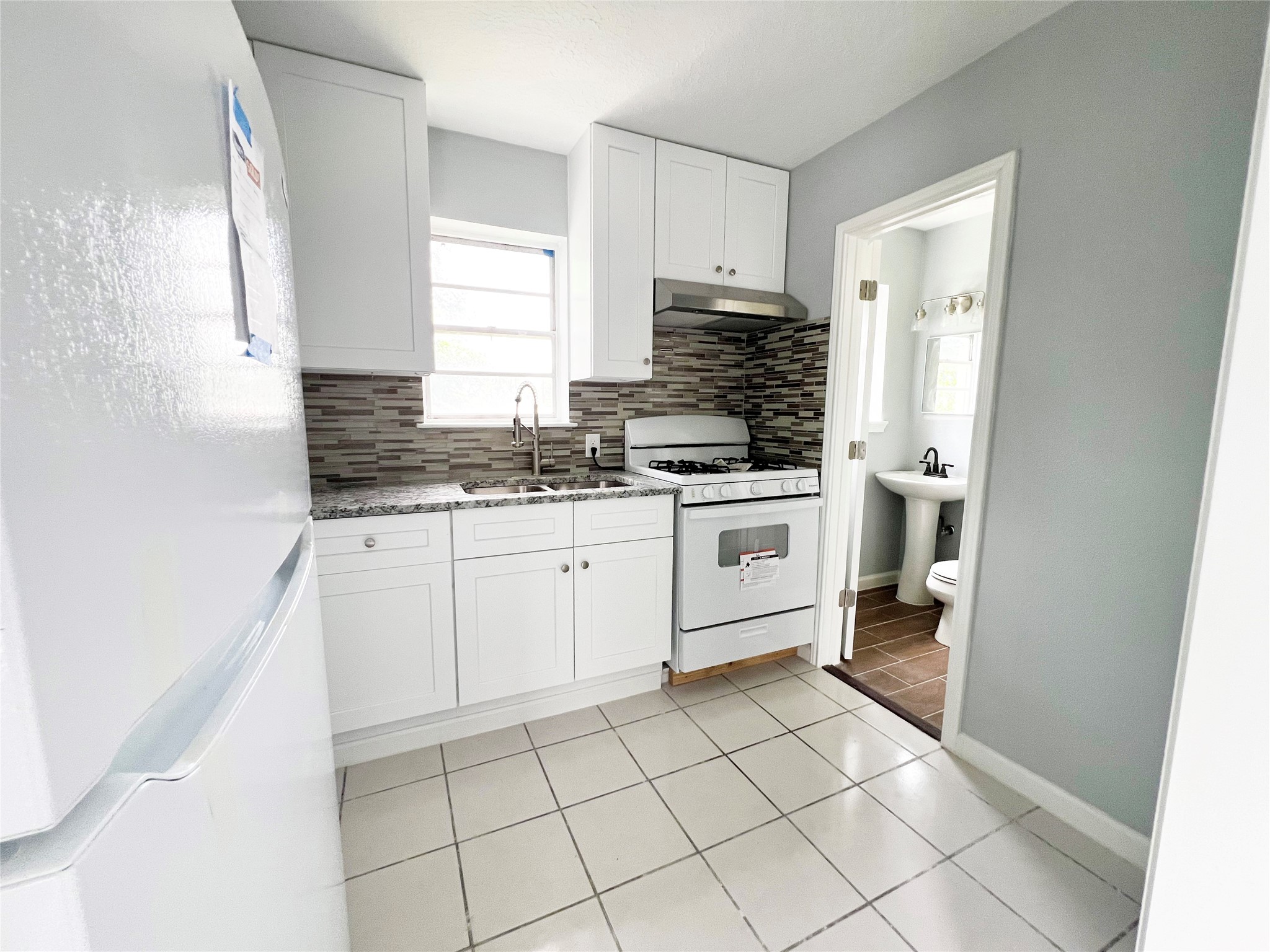 103 Cosmos Street, Unit 4 Houston, TX 77009 - Photo 3 of 8 a kitchen with a stove a sink and a refrigerator
