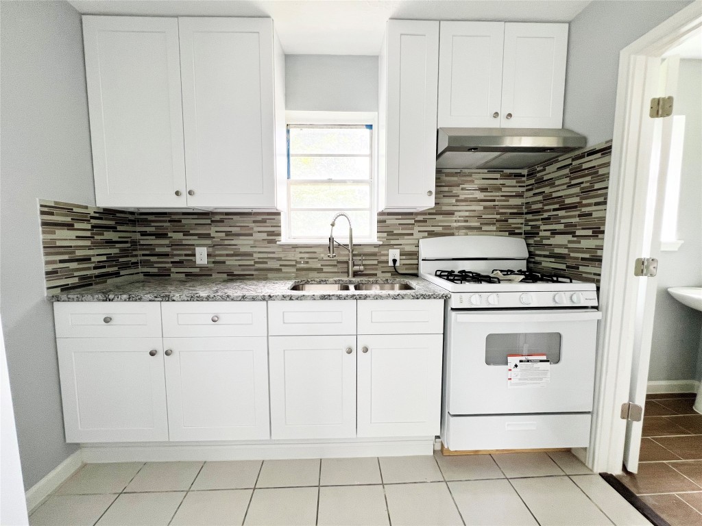 103 Cosmos Street, Unit 4 Houston, TX 77009 - Photo 4 of 8 a kitchen with granite countertop white cabinets and white appliances