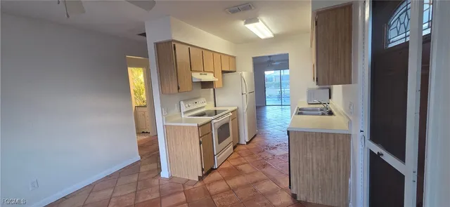 a kitchen with a refrigerator and a stove