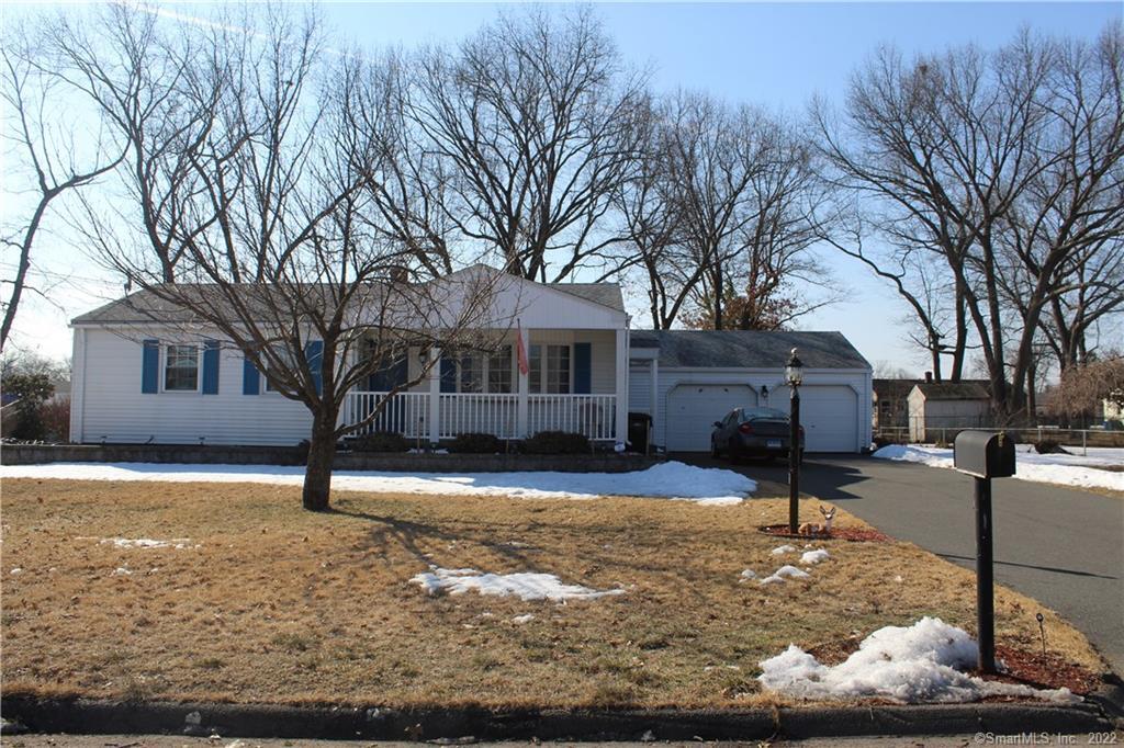 a front view of a house with a yard covered with snow