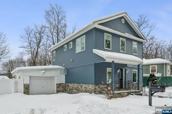 a view of a house with a yard and couches chairs under an umbrella