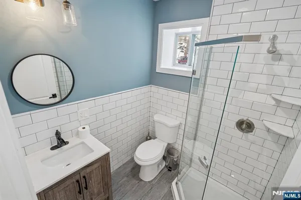 a bathroom with a toilet a sink and mirror