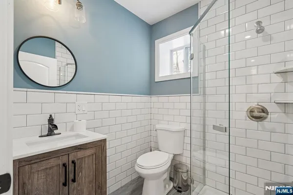 a bathroom with a toilet a sink and mirror