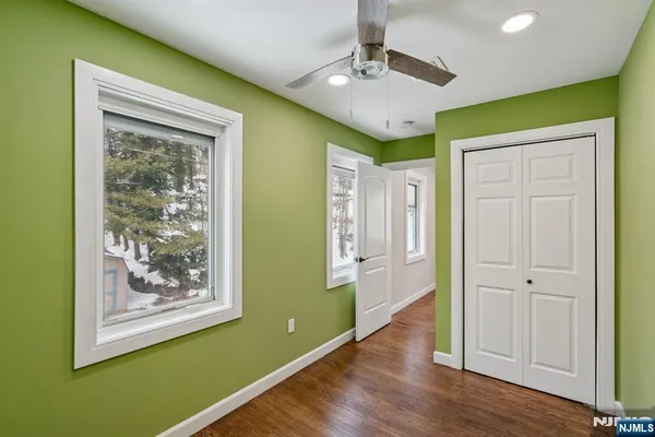 a view of a room with a ceiling fan and wooden floor