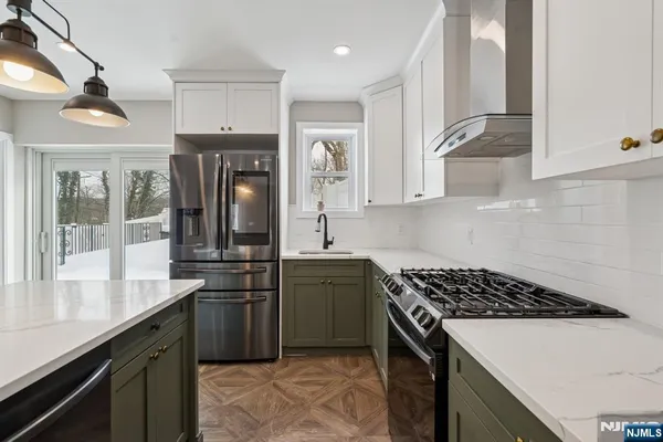 a kitchen with stainless steel appliances granite countertop a sink a stove a refrigerator and island