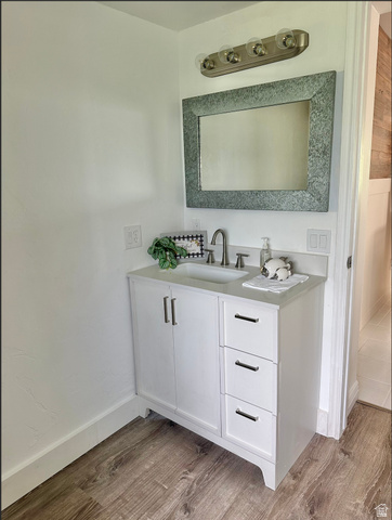1050 West 100 North Provo, UT 84601 - Photo 7 of 16 White vanity with brushed nickel hardware, integrated sink, and wood-finish flooring