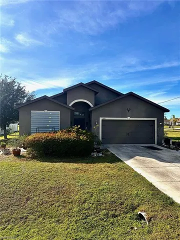 a front view of a house with a yard and garage