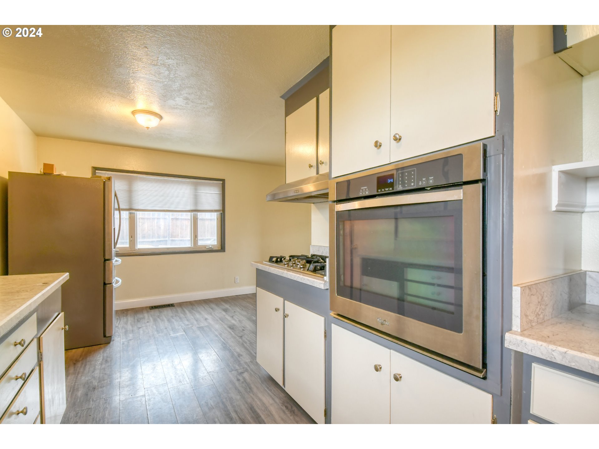 3222 Southwest Hailey Place Pendleton, OR 97801 - Photo 16 of 48 a kitchen with granite countertop white cabinets and refrigerator