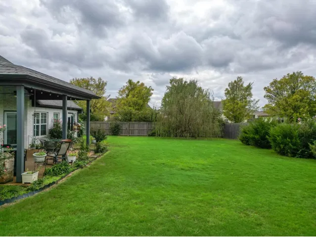 a view of a house with backyard sitting area and garden