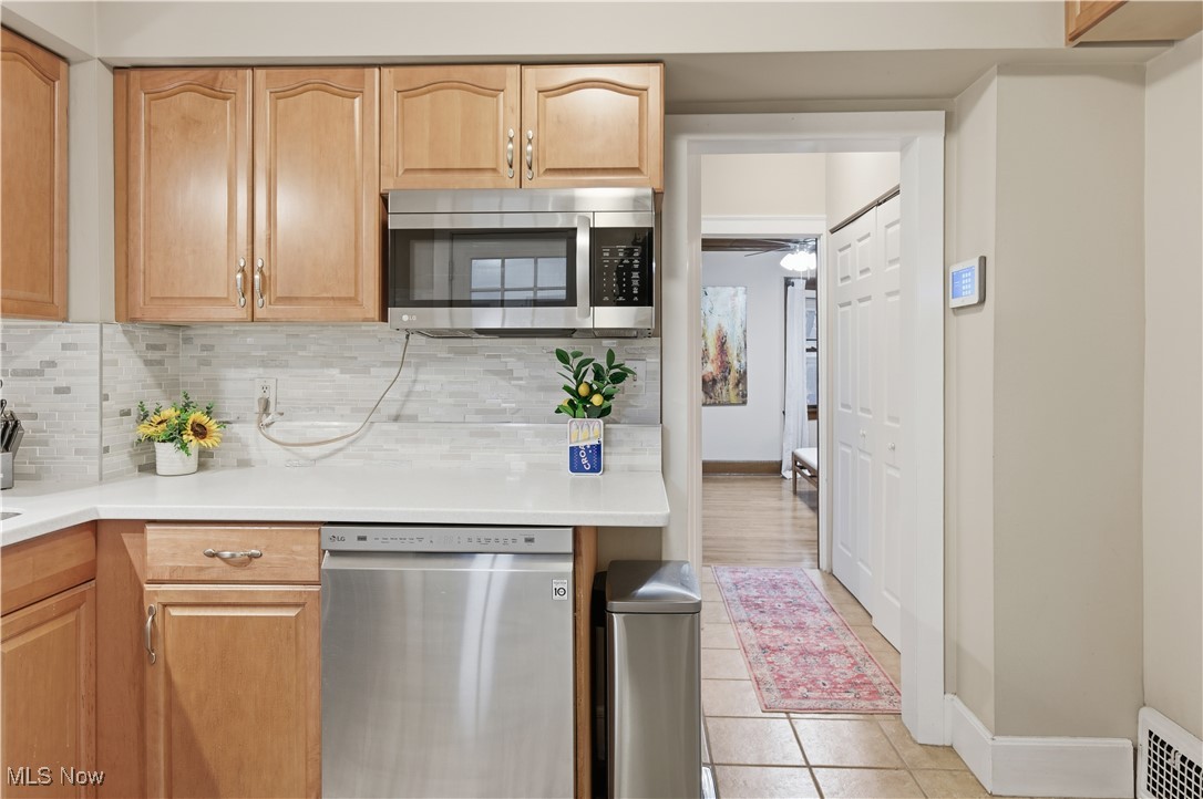 1017 Spring Road Cleveland, OH 44109 - Photo 16 of 47 Kitchen featuring stainless steel appliances, light tile patterned floors, tasteful backsplash, and light brown cabinetry
