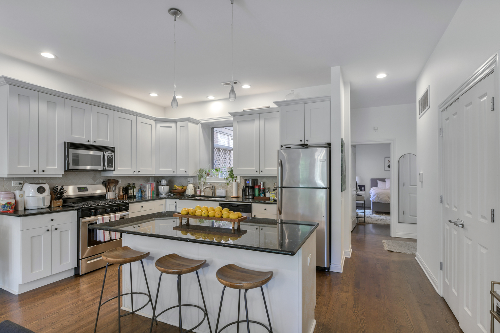 1355 West Washington Boulevard, Unit 2B Chicago, IL 60607 - Photo 2 of 16 a kitchen with refrigerator a microwave a stove and chairs