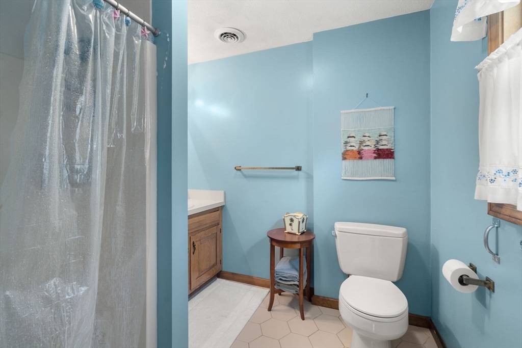 16 Parmenter Road Framingham, MA 01701 - Photo 16 of 34 a white toilet sitting next to a bathroom sink and vanity