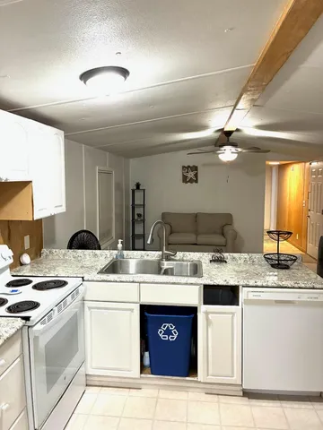 a kitchen with granite countertop a stove sink and cabinets