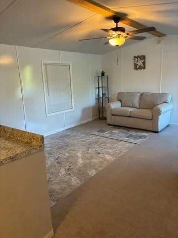 a view of a room with furniture and wooden floor