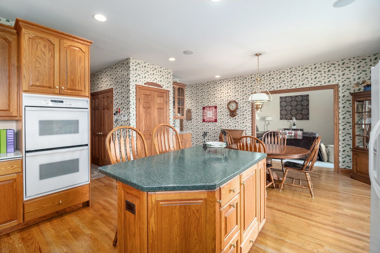 42W545 McDonald Road Elgin, IL 60124 - Photo 15 of 45 a open kitchen with stainless steel appliances granite countertop a stove top oven a dining table and chairs with wooden floor