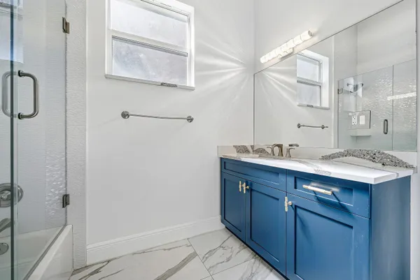 a bathroom with a tub sink shower and mirror