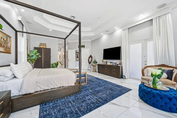 a white house with a yard and palm trees