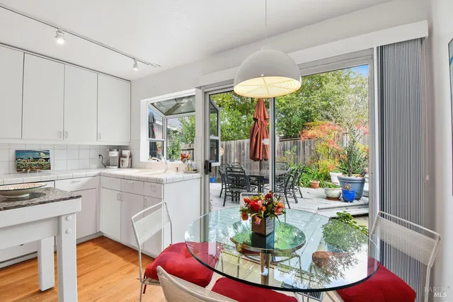 a kitchen with stainless steel appliances granite countertop a stove a sink dishwasher and a dining table with the garden view