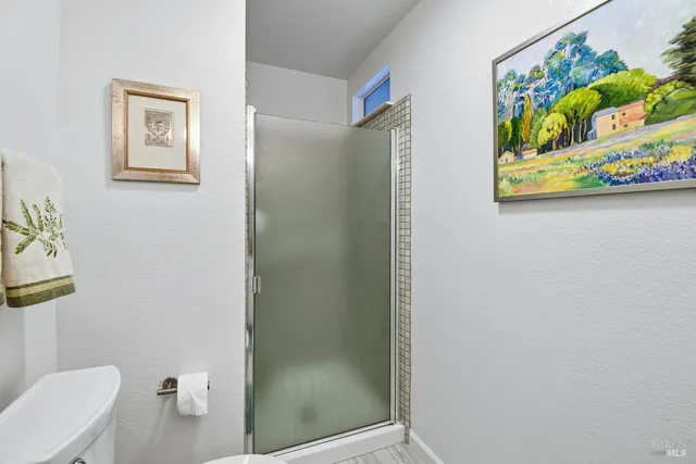 a bathroom with a toilet and painting on the wall