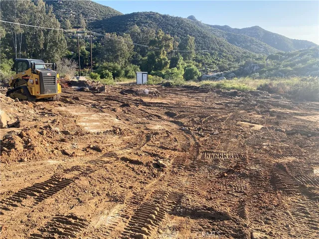 a view of a dry yard with mountains in the background