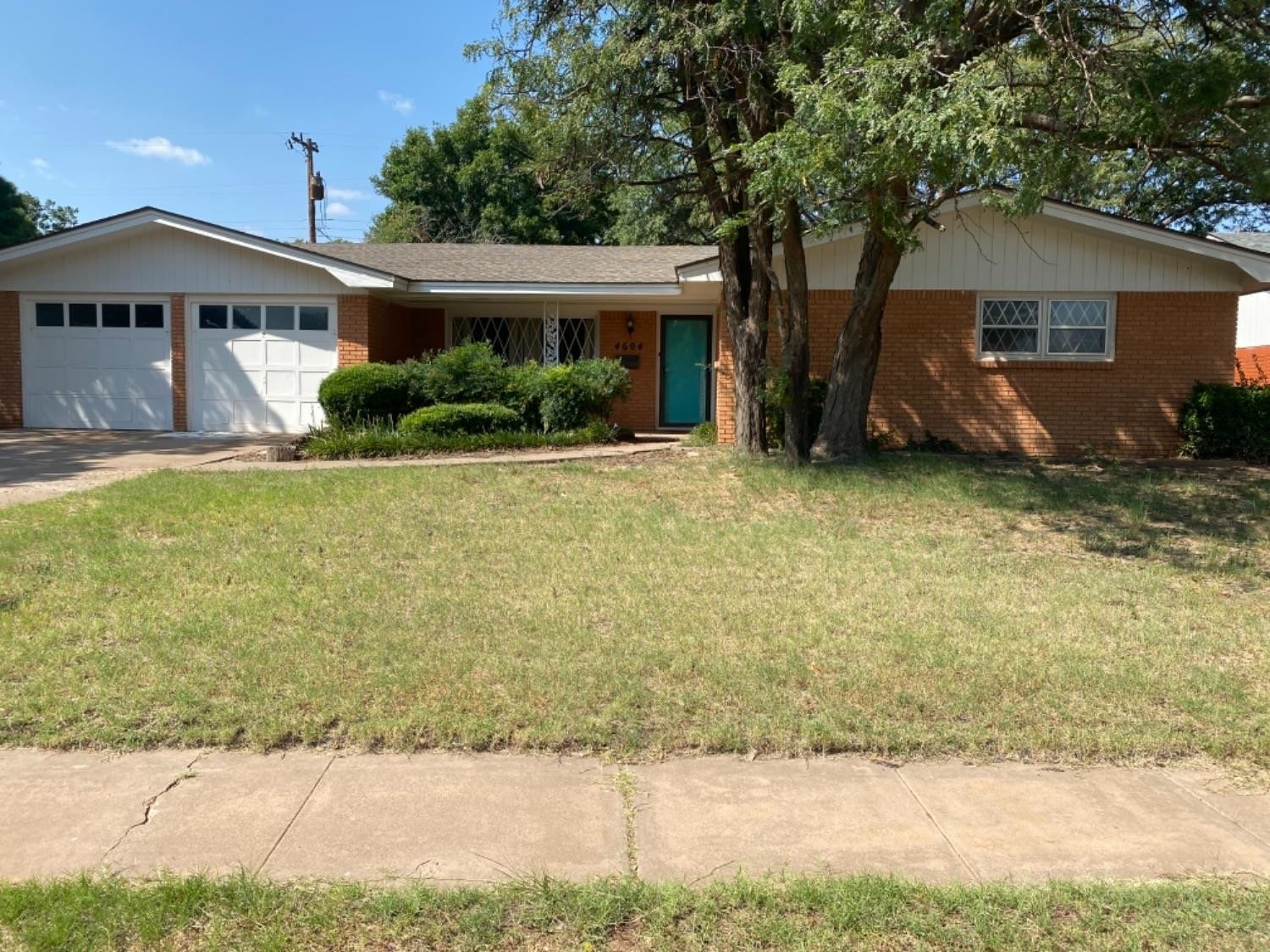 a view of a house with backyard and trees