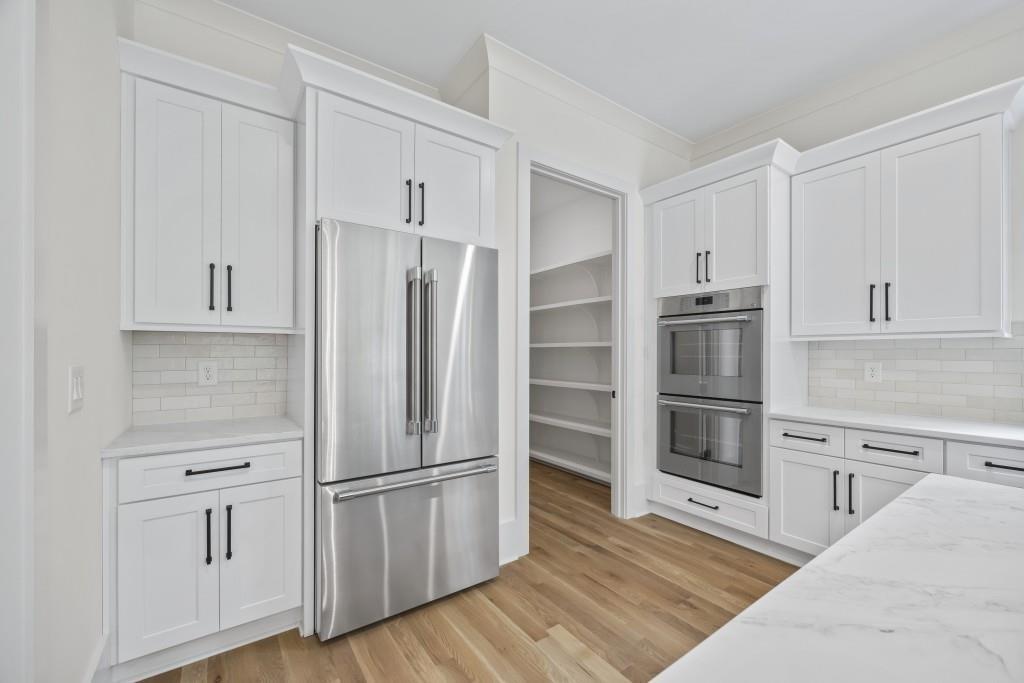 611 Foster Park Lane Madison, GA 30650 - Photo 16 of 54 a kitchen with white cabinets and stainless steel appliances