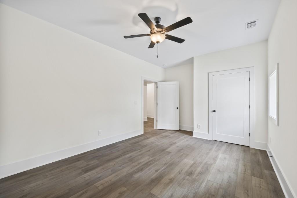 611 Foster Park Lane Madison, GA 30650 - Photo 45 of 54 an empty room with wooden floor and ceiling fan
