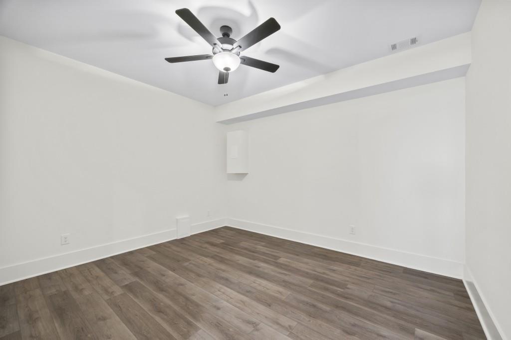 611 Foster Park Lane Madison, GA 30650 - Photo 47 of 54 an empty room with wooden floor and a ceiling fan