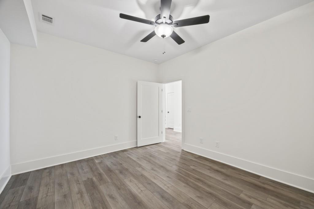 611 Foster Park Lane Madison, GA 30650 - Photo 48 of 54 an empty room with wooden floor and ceiling fan