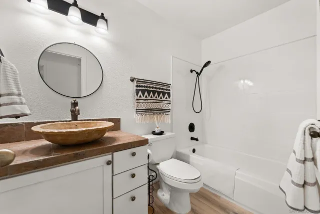 a bathroom with a sink a toilet and a mirror