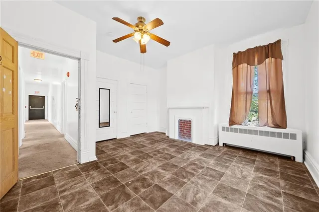 an empty room with windows and fireplace