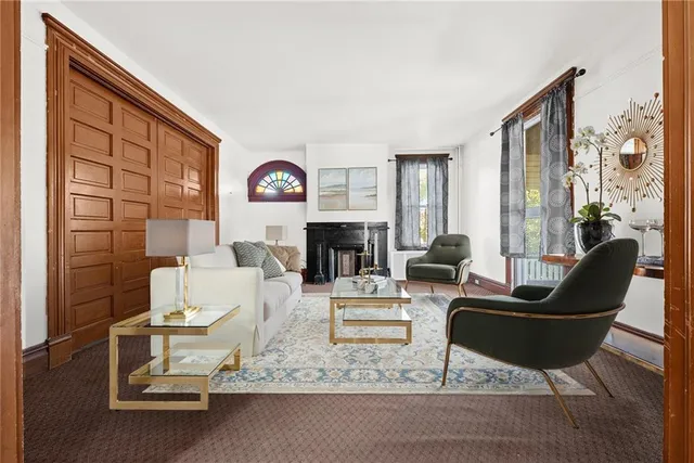 a living room with furniture a fireplace and a large window