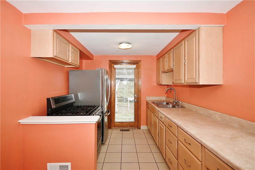 416 Pearce Road Pittsburgh, PA 15234 - Photo 11 of 32 a kitchen with a sink a stove and cabinets