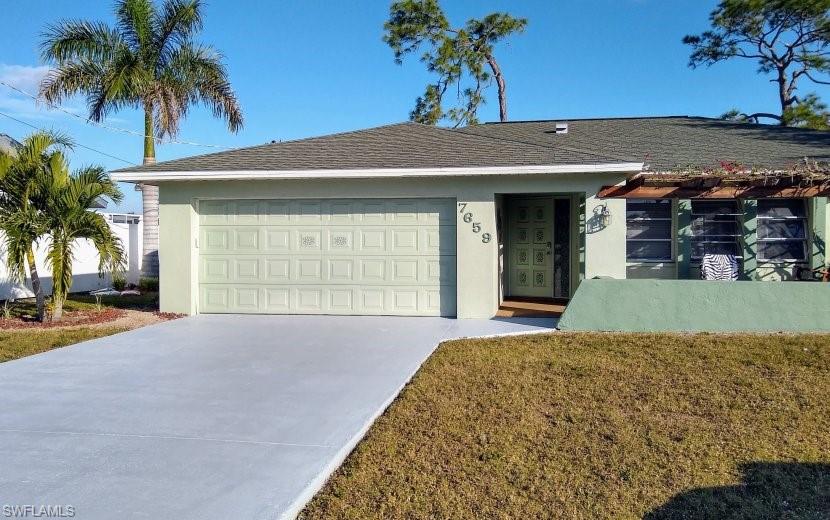 7659 Laurel Valley Road Fort Myers, FL 33967 - Photo 10 of 35 a view of a house with a yard and palm trees