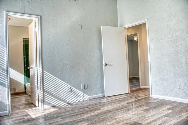 a view of a hallway with wooden floor and entryway