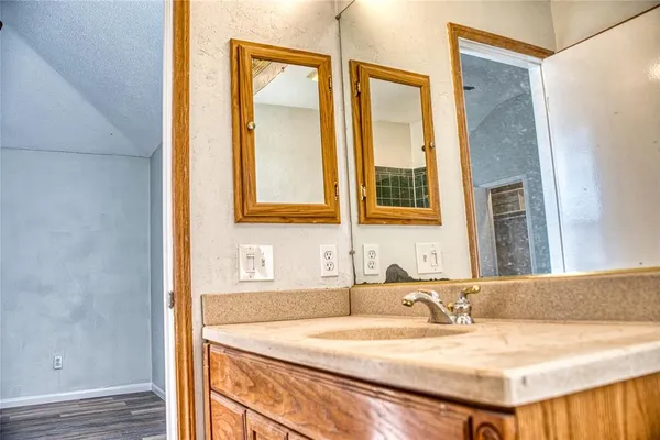 a bathroom with a granite countertop sink and a mirror