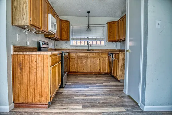 a view of a kitchen with stainless steel appliances granite countertop cabinets and a window