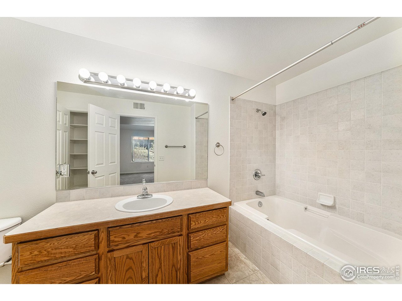 124 Beacon Way, Unit 3 Windsor, CO 80550 - Photo 17 of 22 a bathroom with a tub a double vanity sink and mirror