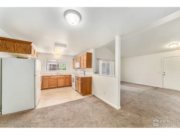 a open kitchen with cabinets and a refrigerator
