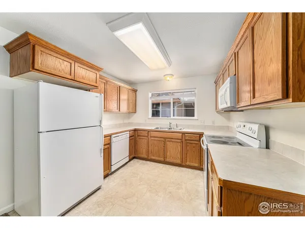 a kitchen with stainless steel appliances granite countertop a refrigerator a stove a sink and a microwave