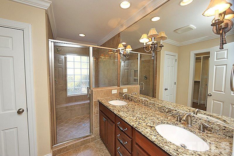 4605 Pitt Street Raleigh, NC 27609 - Photo 17 of 22 a bathroom with a granite countertop sink a large mirror and a shower