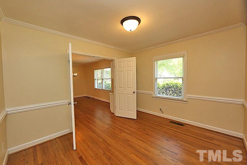 4605 Pitt Street Raleigh, NC 27609 - Photo 6 of 22 an empty room with wooden floor and windows