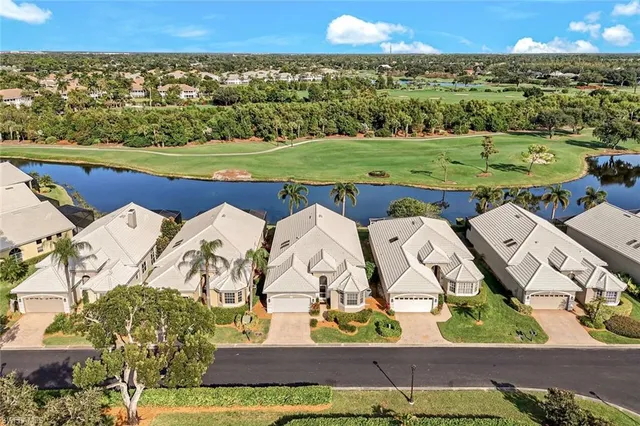 an aerial view of a house with a yard and lake view