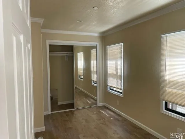 an empty room with windows and closet